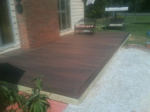 Freshly stained wood deck built against a brick home in Montezuma